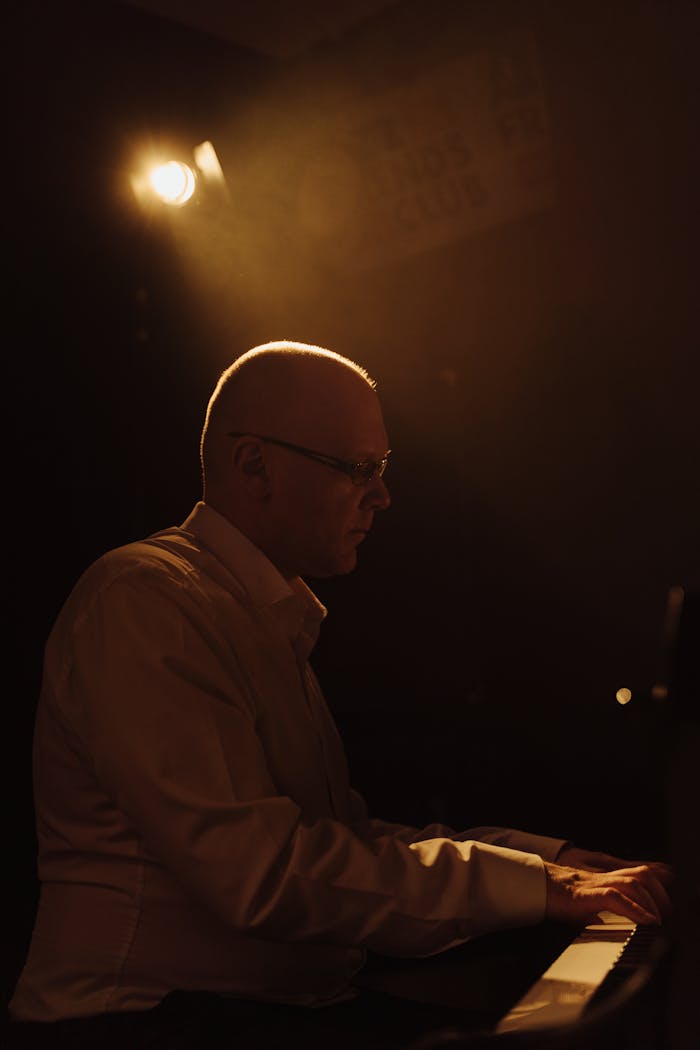 services-01 A focused pianist performing in a dimly lit, intimate setting, creating a moody and artistic atmosphere.